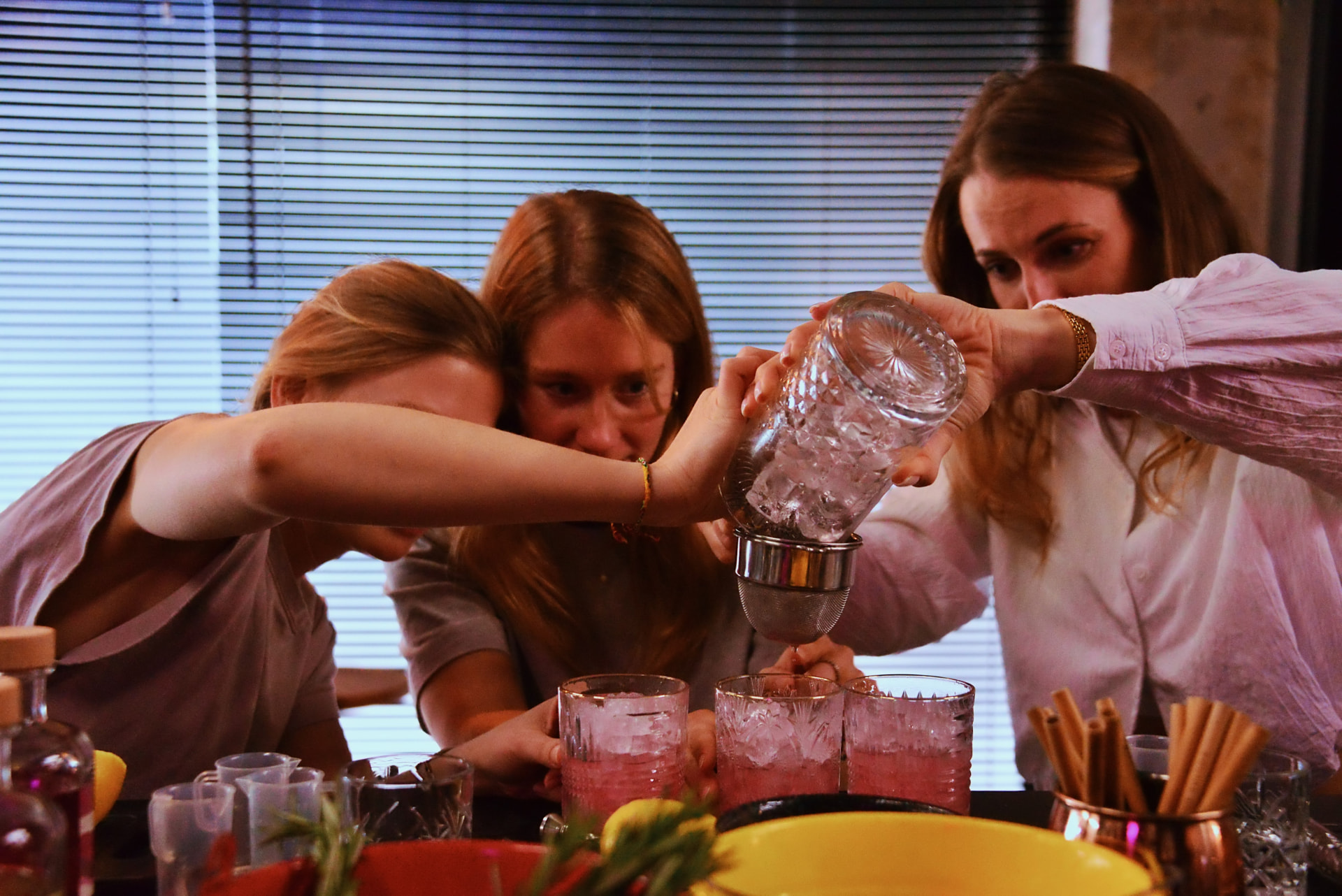 Drie vrouwen zeven samen een cocktail in kristalglazen